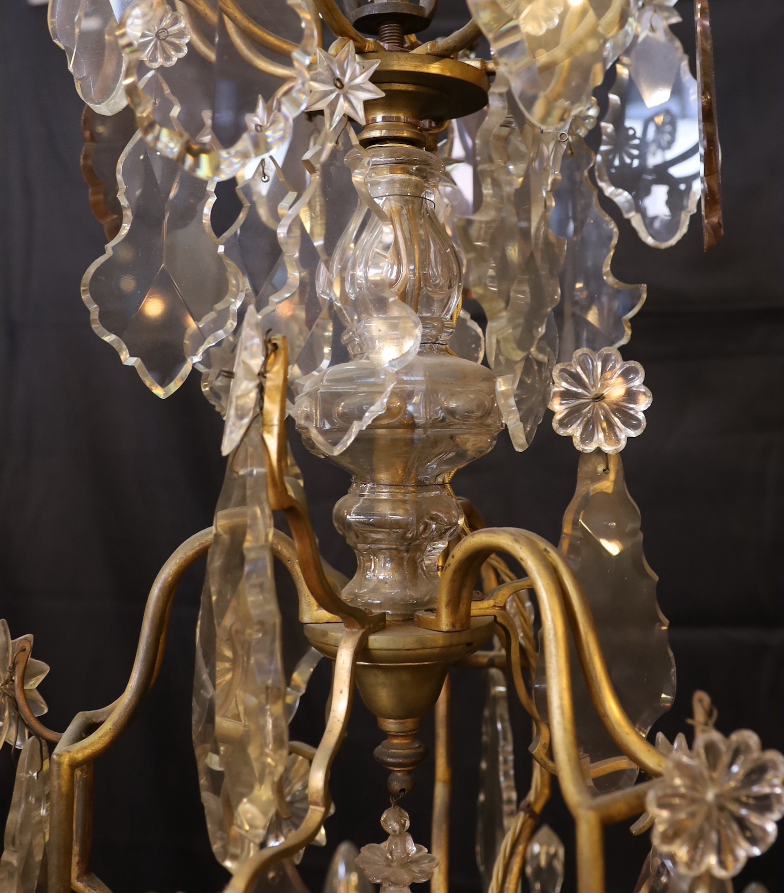 An early 20th century French gilt bronze and cut glass eight light chandelier profusely hung with lozenge and flowerhead drops, drop 110cm. width 65cm